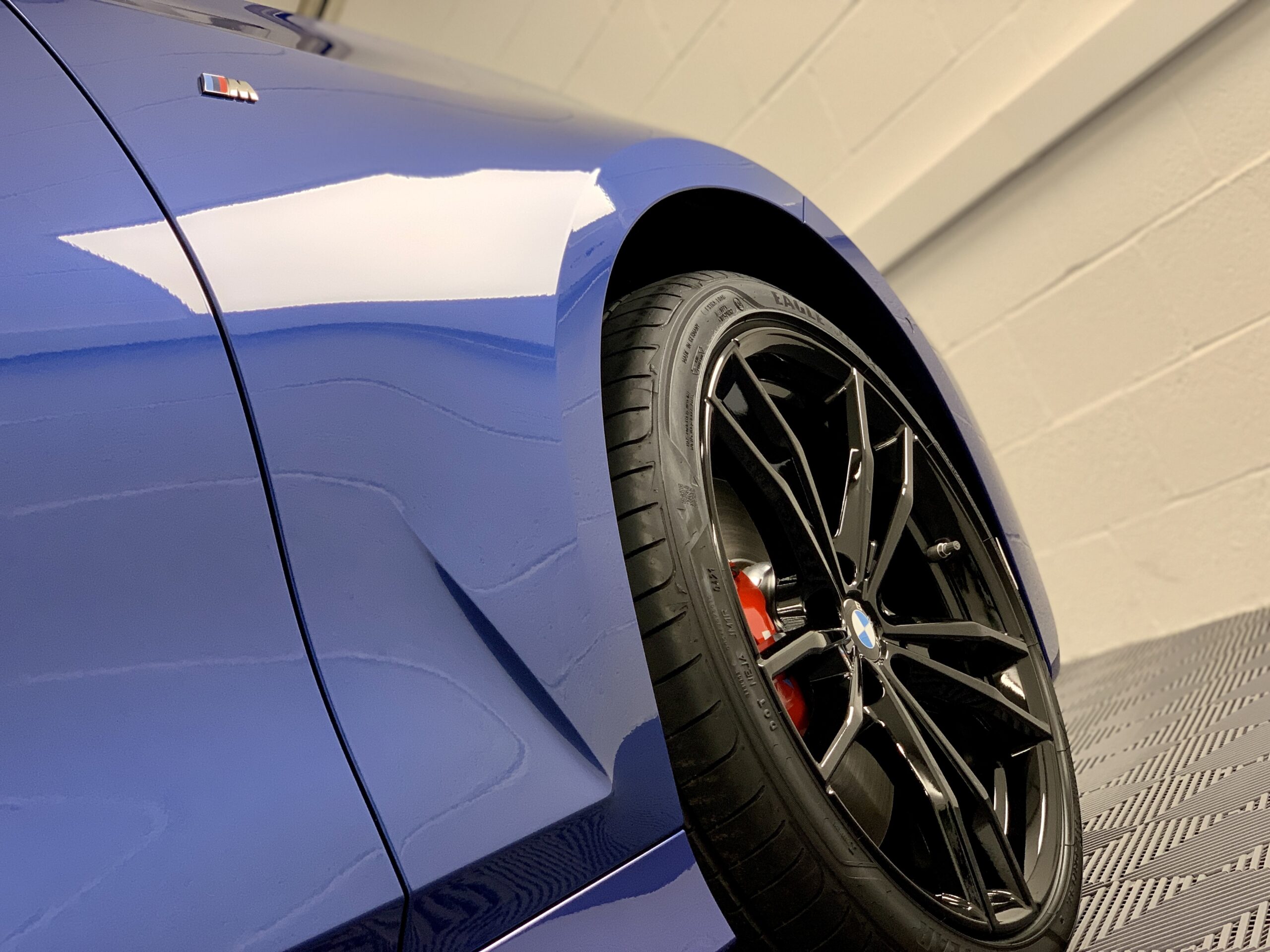 Blue BMW performance car in the Bear’s Detailing studio, with its front wheel and bodywork visible
